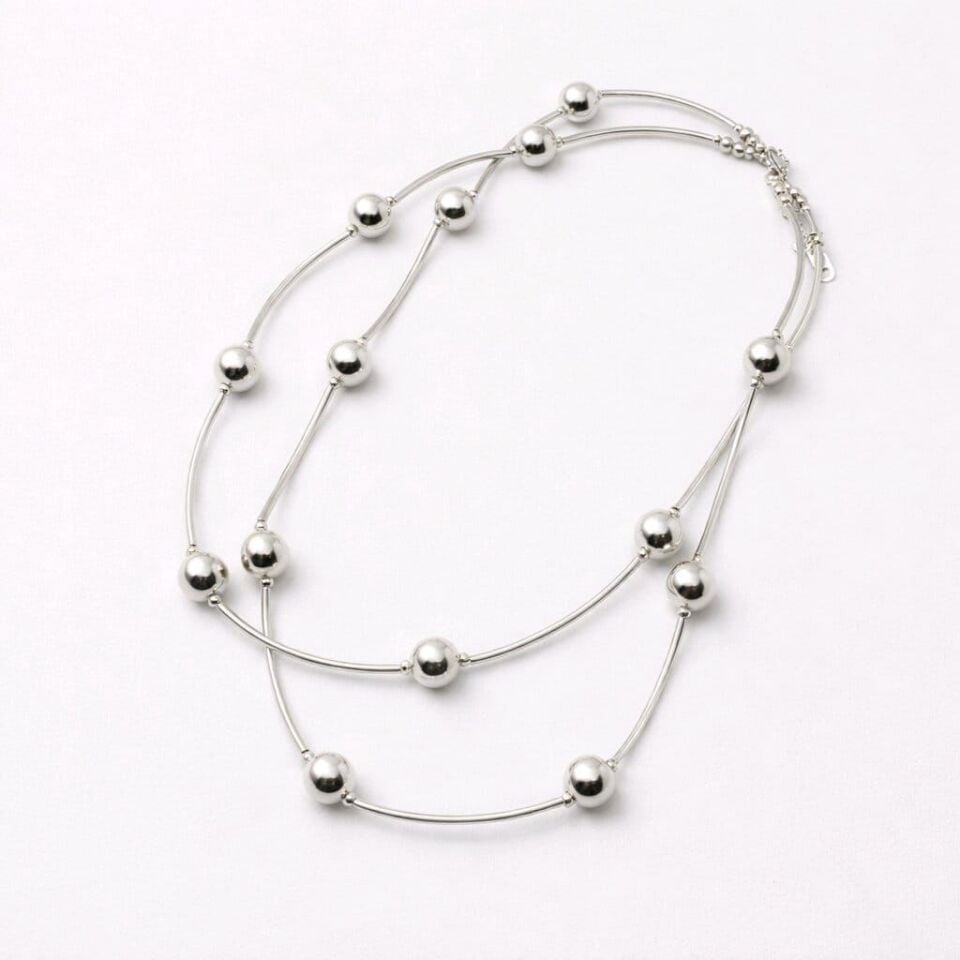 GÜMÜŞ RENGİNDE ÜZERİNDE TOP DETAYLARIN OLDUĞU ÇELİK KOLYE