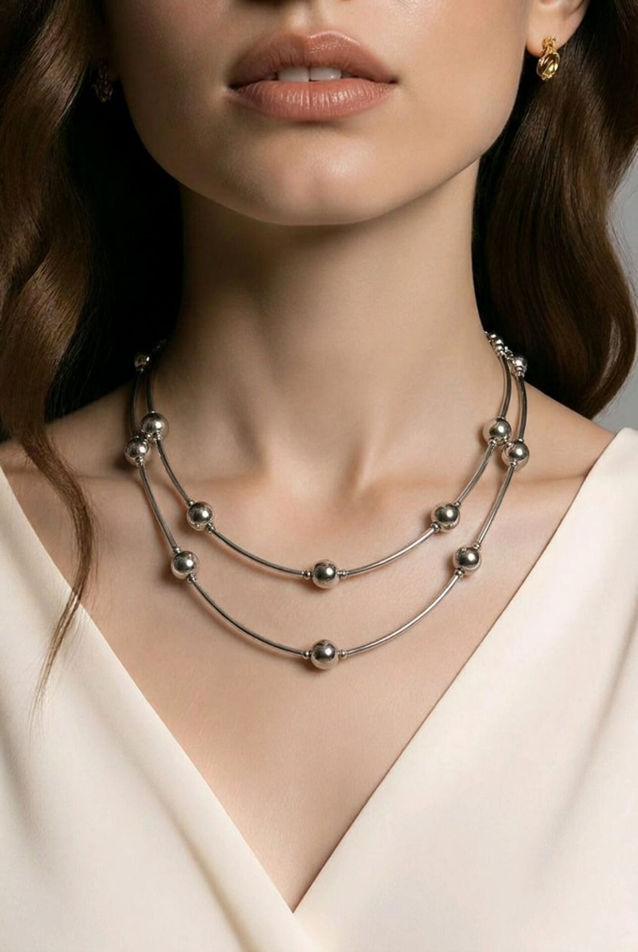 GÜMÜŞ RENGİNDE ÜZERİNDE TOP DETAYLARIN OLDUĞU ÇELİK KOLYE