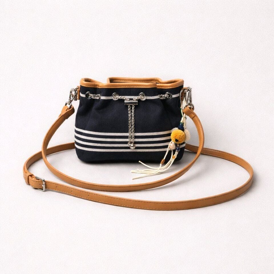 LACİVERT BEYAZ ÇİZGİLİ GÖVDE, TABA RENGİ DETAYLARA SAHİP ZİNCİR DETAYI İLE BÜZGÜLÜ ÇANTA